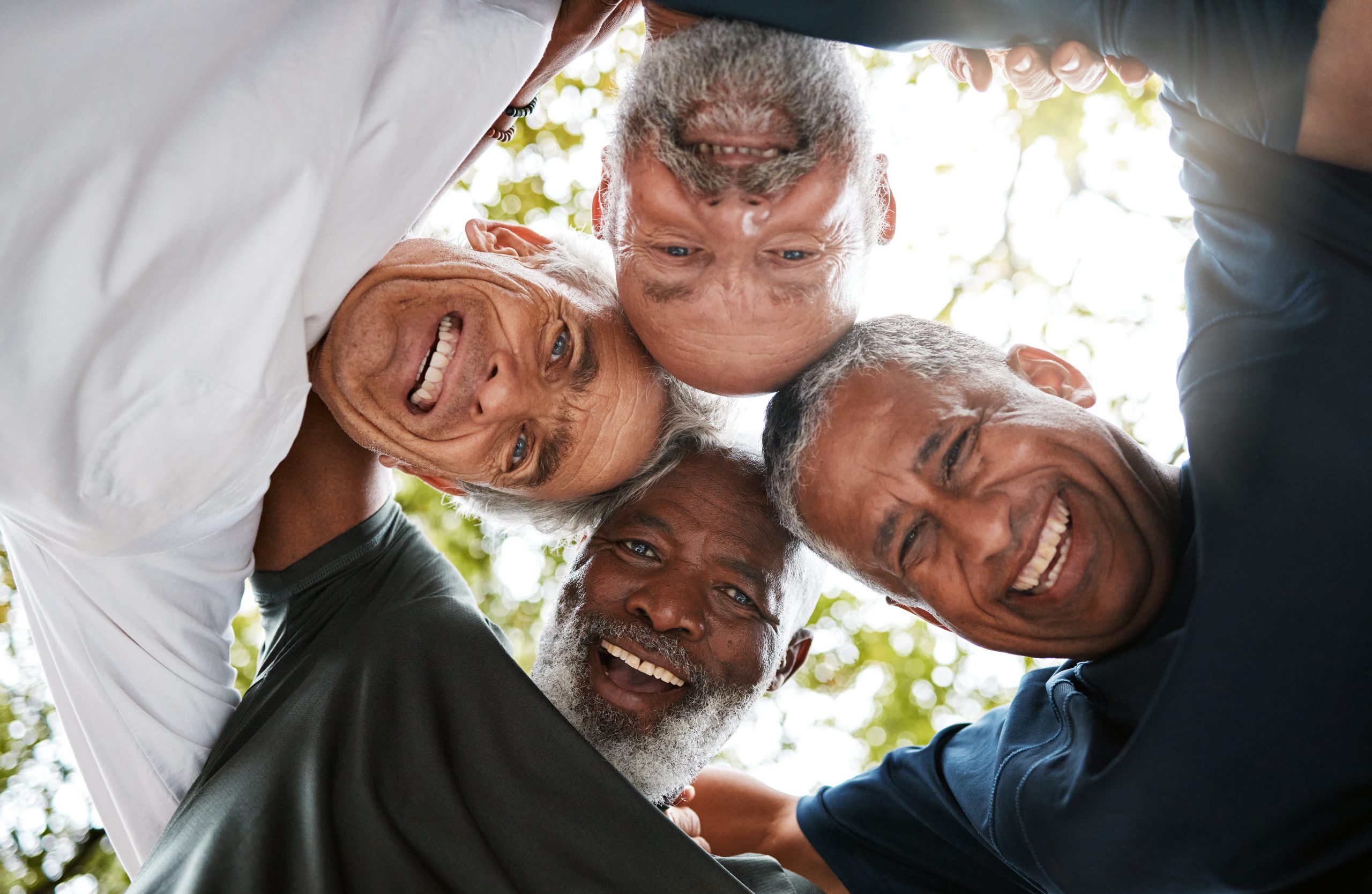 Senior men, friends and community together in a circle for support, trust and diversity with a smil.